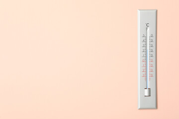 Weather thermometer on pink wall. Space for text