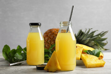 Delicious pineapple juice and fresh fruit on white table