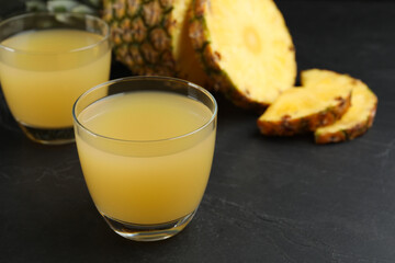 Delicious fresh pineapple juice on black table