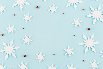 Christmas composition. Pattern made of snowflakes, red decorations on blue background. Christmas, winter, new year concept. Minimal style. Flat lay, top view.