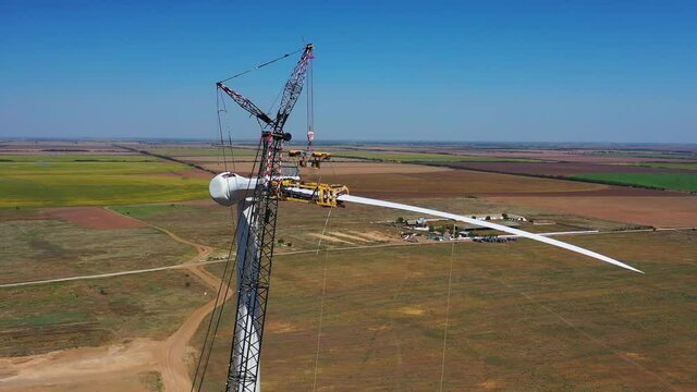 High altitude work, people are assembling a wind turbine, massive construction