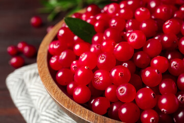 Plate with tasty ripe cranberries on table, closeup