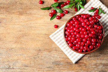 Tasty ripe cranberries on wooden table, flat lay. Space for text