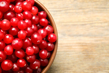 Tasty ripe cranberries on wooden table, top view. Space for text