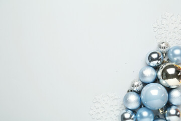 Flat lay composition with Christmas balls and decor on light background, space for text