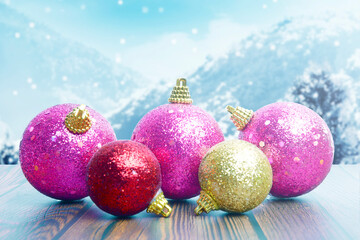 Colorful Christmas ball on wooden table with snowfall background