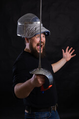 Middle aged bearded man with epee and helmet