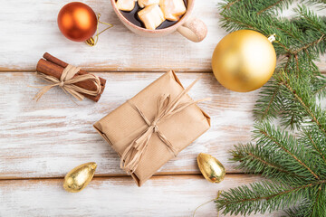 Christmas or New Year composition. Decorations, box, balls, fir and spruce branches, cup of coffee, on a white wooden background. Top view.