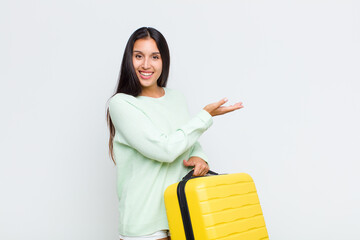 pretty woman smiling cheerfully, feeling happy and showing a concept in copy space with palm of hand