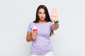 pretty woman looking serious, stern, displeased and angry showing open palm making stop gesture