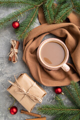 Christmas or New Year composition. Decorations, fir and spruce branches, cup of coffee, on a gray concrete background. Top view. © zgurski1980