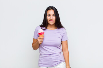 pretty woman looking puzzled and confused, biting lip with a nervous gesture, not knowing the...