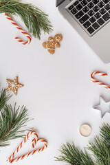 Christmas, winter, new year composition. Home office desk workspace with Fir tree branches, gingerbread, candies, candles on white background. Flat lay, top view, copy space