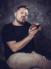 Mature bearded man dressed in t-shirt reading small book