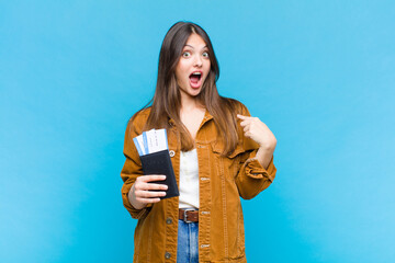 pretty woman looking shocked and surprised with mouth wide open, pointing to self