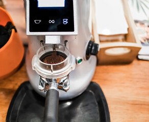 Coffee while grinding in a coffee machine grinder.barista handhold grinding freshly roasted coffee bean