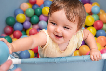 Fototapeta na wymiar child in the play pool with colorful balls