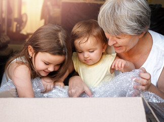 children and grandmother open the box.