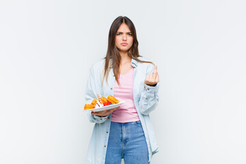 pretty woman looking puzzled and confused, biting lip with a nervous gesture, not knowing the...