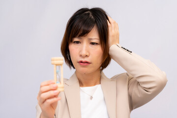 砂時計を見て時間を気にする女性