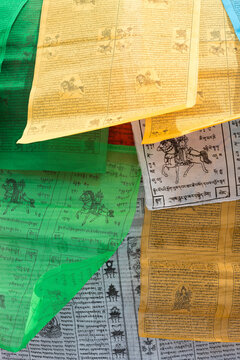 Closeup of Tibetan colored  religious flags with Old Sanskrit and religious icons printed on the fabric. The design never change. Tibet province, China 2013