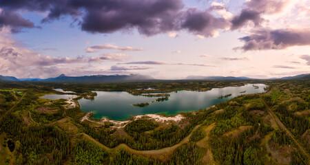 Beautiful Panoramic View of Scenic Lake, Islands and Forest in Canadian Nature. Colorful Sunset Sky. Aerial Done Shot taken near Klondike Highway. Lewes Lake, South of Whitehorse, Yukon, Canada. © edb3_16