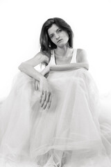 Fototapeta premium Young beautiful woman sitting in tulle dress monochrome portrait