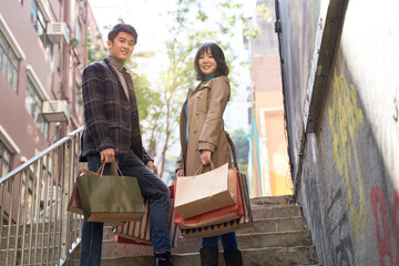 happy asian couple returning from a shopping spree