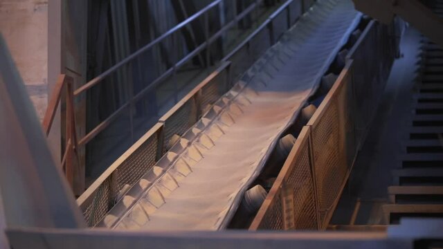 Moving conveyor belt line at the factory. Stock footage. Conveyor belt with sand at the plant of construction materials production, heavy industry concept.