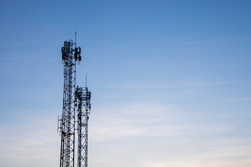 Two Telecom cell phone or telecommunication masts with blue sky backdrop, telecom tower infrastructure for background uses