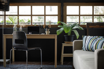 Modern home office creative space perfect for working from home lifestyle with laptop on the desk and sofa in the living room, Quarantine isolation during the Coronavirus (COVID-19) health crisis