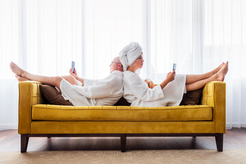 Couple is relaxing with mobile phones.