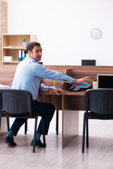 Young male employee in industrial espionage concept