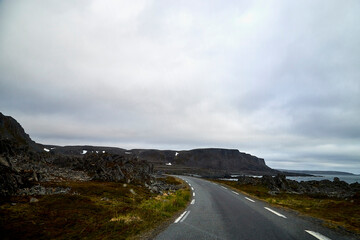 Landscape with road in tundra in Norway at cloudy evening
