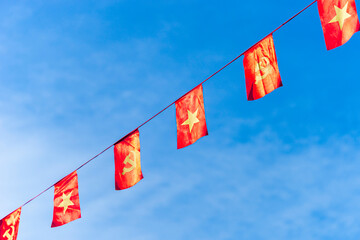 Vietnamese red with yellow star flag and Communist Party of Vietnam flag. Waving colorful national Vietnamese flag in blue sky.