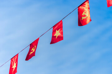 Vietnamese red with yellow star flag and Communist Party of Vietnam flag. Waving colorful national Vietnamese flag in blue sky.