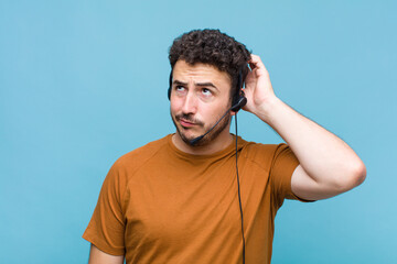 young man feeling puzzled and confused, scratching head and looking to the side