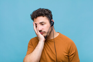 young man feeling bored, frustrated and sleepy after a tiresome, dull and tedious task, holding...