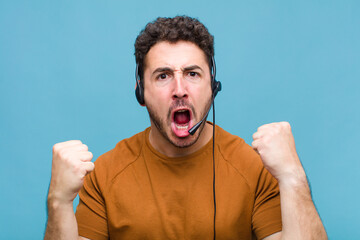 young man shouting aggressively with an angry expression or with fists clenched celebrating success