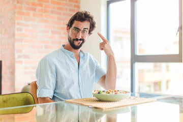 bearded man feeling confused and puzzled, showing you are insane, crazy or out of your mind