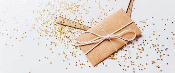 Gift and blank note with envelope, gold glitter stars on white background