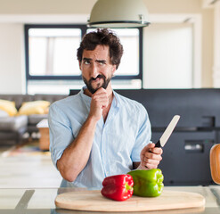 bearded man thinking, feeling doubtful and confused, with different options, wondering which...