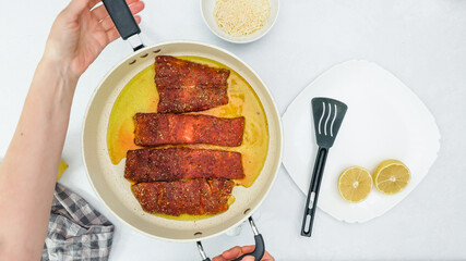 Smoked paprika roasted salmon  recipe. Fish slices close up on frying pan directly from above,...