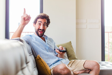 bearded man feeling like a happy and excited genius after realizing an idea, cheerfully raising...