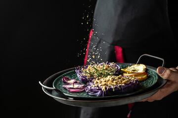 Traditional German cuisine. vegetables dish of red cabbage baked with nuts, quince and apples, flying nuts scattering in a freeze motion