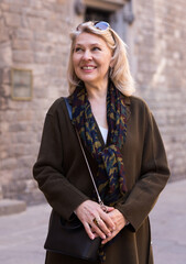 Portrait of positive woman sightseeing in european city. High quality photo