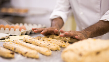 Obraz na płótnie Canvas chef kneading dough on table in bakery