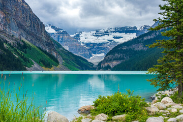 Lake Louise in summer sunny day morning. Blue sky and white clouds reflected on the turquoise color lake water surface. Beautiful landscape in Banff National Park, Alberta, Canada.