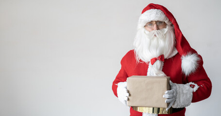 Santa Claus is holding a gift in a kraft paper box in front of him. It stands near the space for the text.
