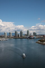 Fototapeta na wymiar View of Vancouver False Creek waterfront skyline with snow mountain during springtime Seen from Cambie Bridge in the downtown of Vancouver, British Columbia, Canada.